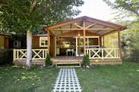 Camping Bassegoda Park  -  Mobilheim vom Campingplatz mit Esstisch und Liegestühlen auf der Veranda