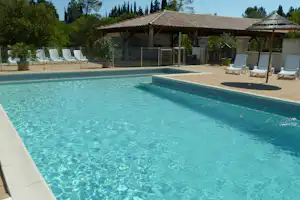 Schwimmbecken im Freien des Camping Beau Rivage in Cévennes mit Liegestühlen und Sonnenschirmen