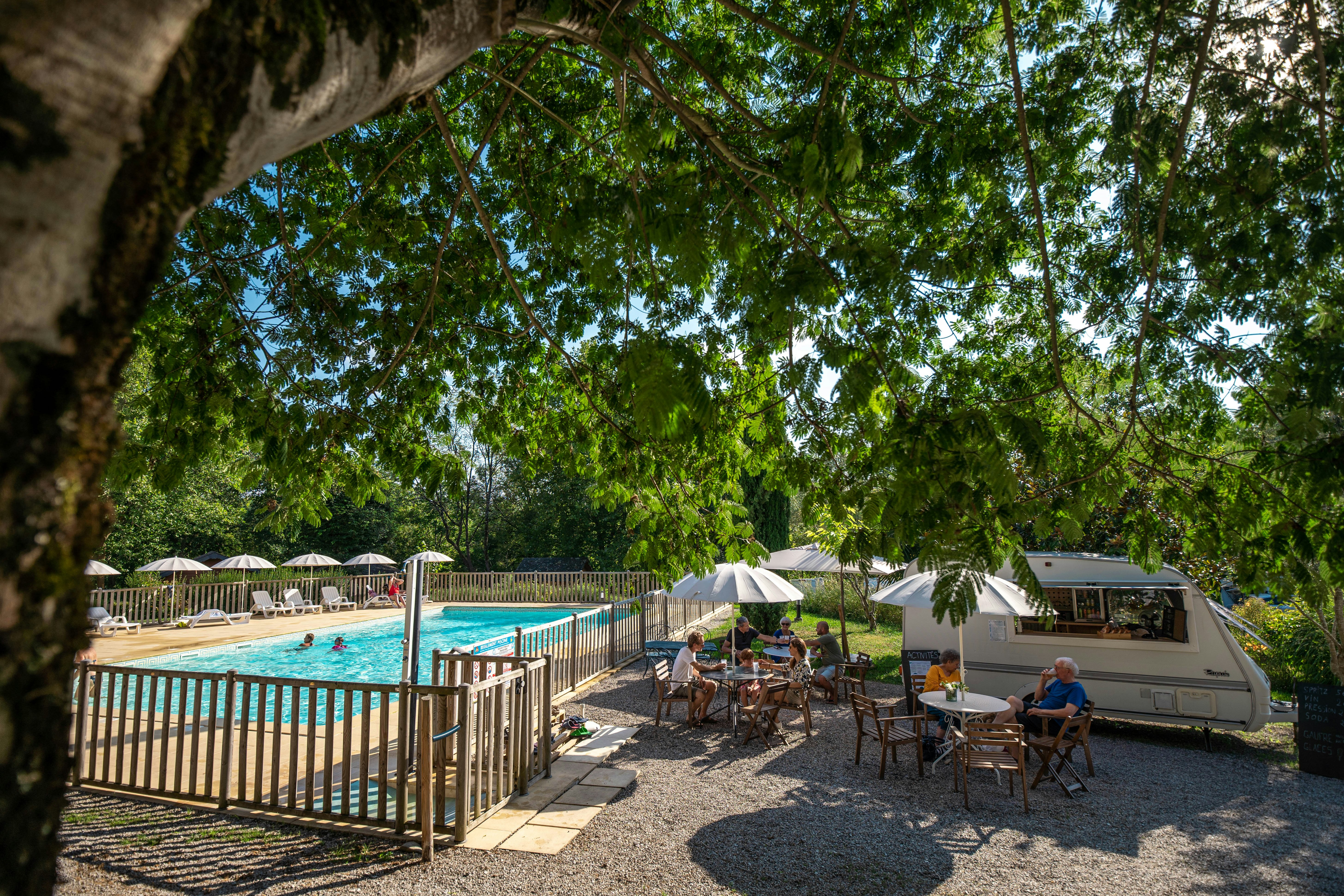 Camping Beau Rivage (Navarrenx) - gejiester Aufentahltsbereich mit Sitzgelegenheiten unter Sonnenschirmen neben dem Swimmingpool