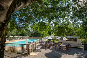 Camping Beau Rivage (Navarrenx) - gejiester Aufentahltsbereich mit Sitzgelegenheiten unter Sonnenschirmen neben dem Swimmingpool