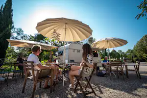 Camping Beau Rivage (Navarrenx) - kleine, gemütliche Wohnwagenbar mit Sitzgelegenheiten unter Sonnenschirmen neben dem Swimmingpool