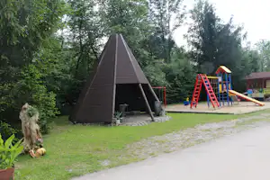 Camping Belá - Holzzelt und Kinderspielplatz mit Rutsche und Schaukel auf dem Campingplatz