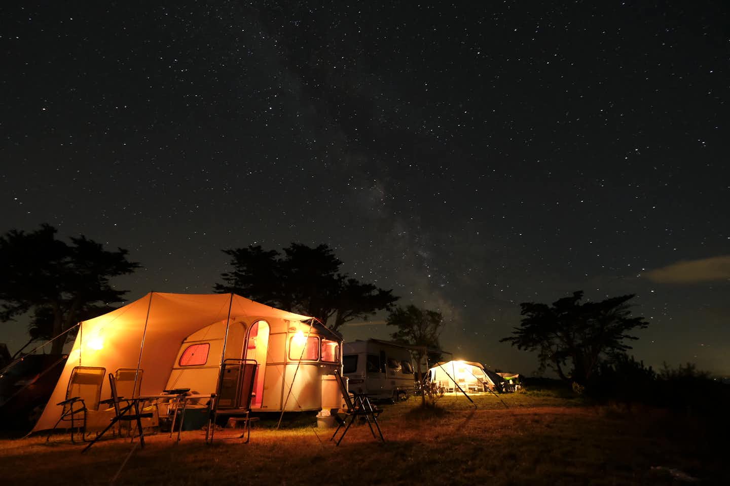 Camping Bel Sito - Wohnwagen mit Vorzelten auf den Stellplätzen bei Nacht unter dem Sternenhimmel