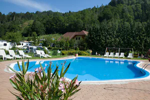 Camping Bella Austria - Campingplatz mit Pool, Liegestühlen und Sonnenschirmen im Grünen