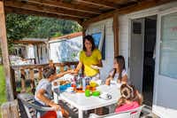 Camping Bella Austria - Familie beim Essen auf der Terrasse im Grünen
