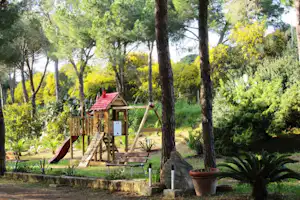 Camping Bella Sardinia - Spielplatz vom Campingplatz zwischen Bäumen