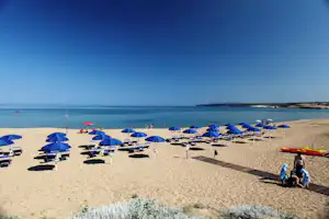 Camping Bella Sardinia - Strand vom Campingplatz am Mittelmeer mit Sonnenschirmen und Liegestühlen