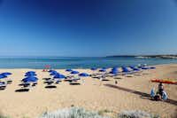 Camping Bella Sardinia  - Strand vom Campingplatz am Mittelmeer mit Sonnenschirmen und Liegestühlen
