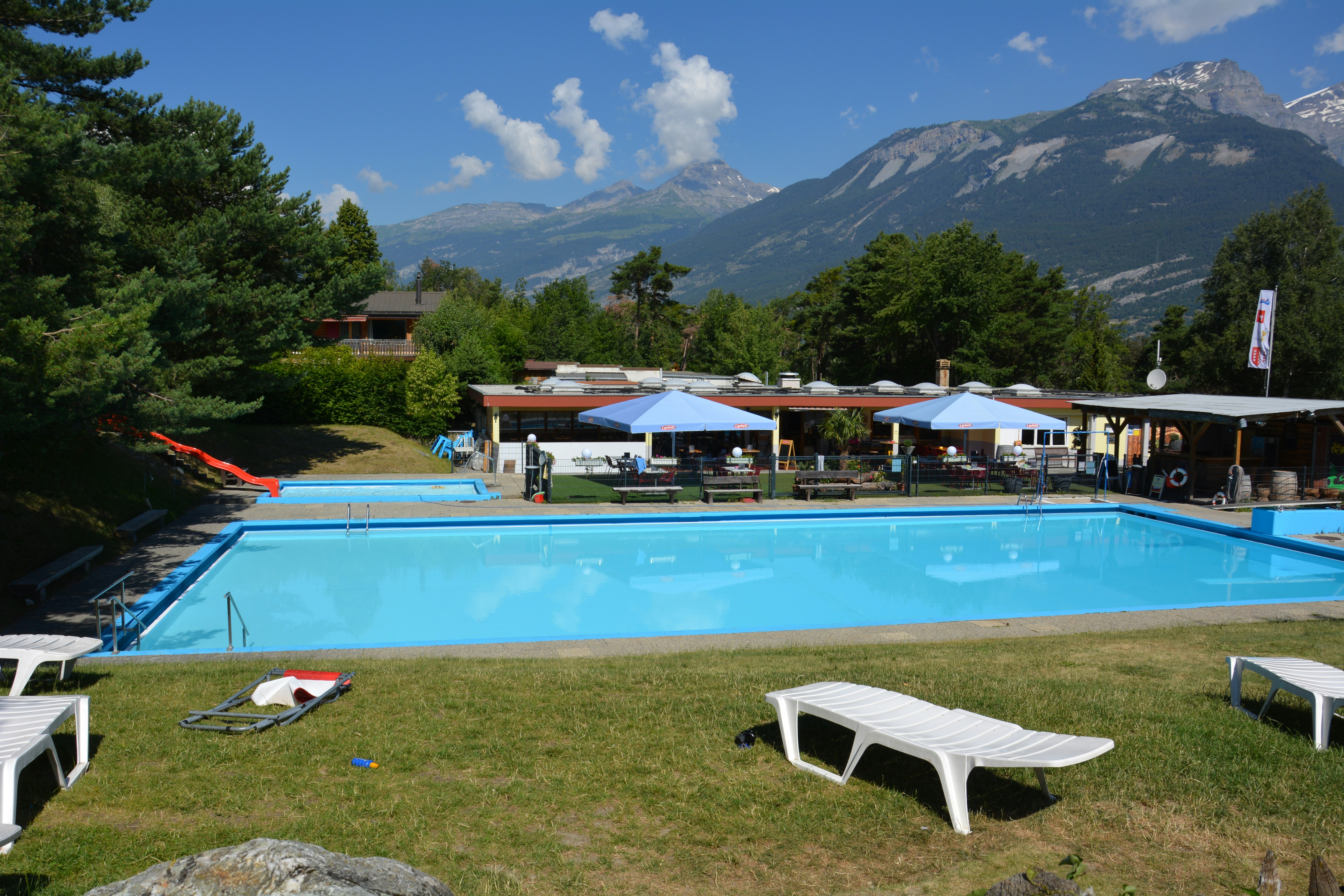 Camping Bella-Tola - Poolbereich mit Liegewiese im Vordergrund