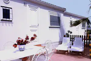 Camping Bellavista - Mobilheim vom Campingplatz mit Esstisch und Liegestühlen auf der Veranda