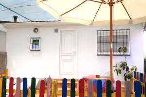 Camping Bellavista - Außenansicht Mobilheim mit überdachter Terrasse und Sonnenschirm auf dem Campingplatz