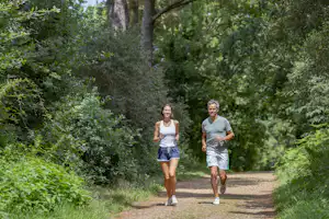 Camping Sandaya Belle Plage Yelloh! Village Belle Plage - Gäste joggen auf den Spazierwegen im Wald