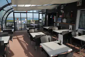 Camping Bellevue Mer - Wintergarten des Restaurants mit Esstischen und Stühlen