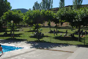 Camping Berceo - Liegewiese mit Bäumen am Pool vom Campingplatz