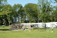 Camping Beringerzand - Sandkasten mit Klettergeräten vor  Wohnwagen- und Zeltstellplätzen