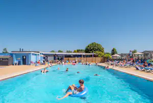 Camping Beverley Park - Pool im Freien mit Liegestühlen und Sonnenschirmen