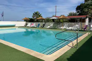 Camping Bleu Mer - Pool im Freien mit Liegestühlen und Sonnenschirmen