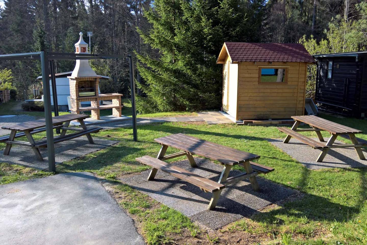 Camping Bois du Couvent - Sitzgelegenheiten und öffentlicher Grill auf dem Campingplatz