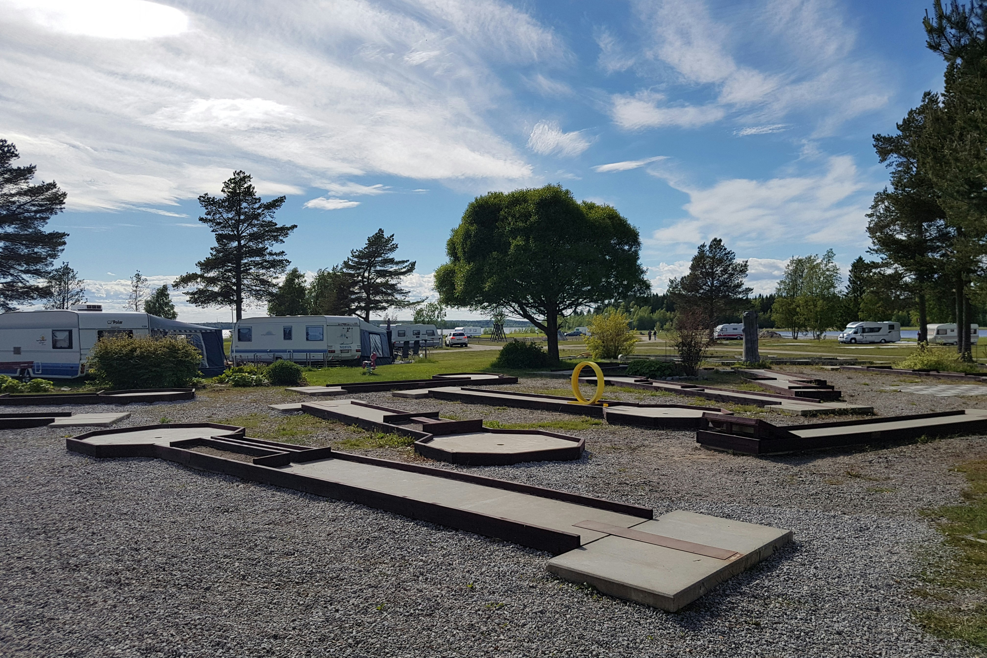 Camping Borgaruddens Havsbad - Minigolfplatz im Vordergrund, Wohnwagen- und Zeltstellplatz und das Meer im Hintergrund