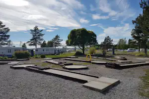Camping Borgaruddens Havsbad - Minigolfplatz im Vordergrund, Wohnwagen- und Zeltstellplatz und das Meer im Hintergrund