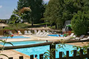 Camping Brin d'Amour - Poolbereich vom Campingplatz mit Wasserrutsche und Liegestühlen in der Sonne
