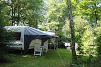 Camping Brin d'Amour - Wohnmobilstellplatz vom Campingplatz unter Bäumen