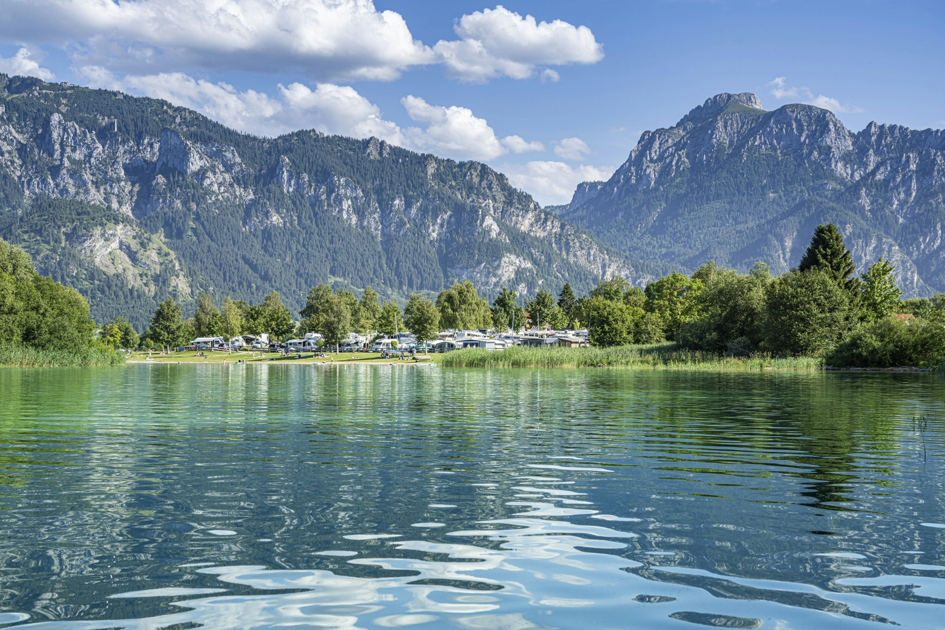 Camping Brunnen - Blick auf den See mit Bergen im Hintergrund