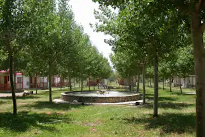 Camping Bungalowpark Isábena - Bungalows umringen einen Garten mit Brunnen
