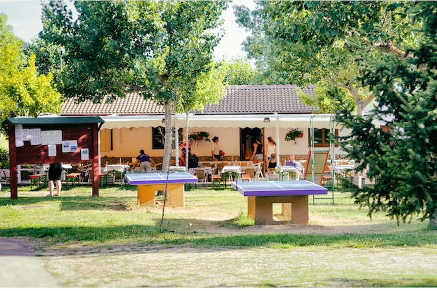 Camping Bungalowpark Isábena - Gebäude des Campingplatzes mit Tischtennisplatten und Rutsche davor