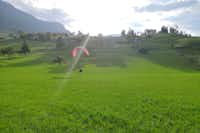 Camping Buosingen - landender Paraglider auf einer Wiese in der Nähe des Campingplatzes