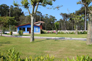 Camping Cabo Mayor - Zeltwiese mit einem Bungalow im Hintergrund