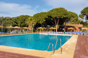 Camping Cabopino - Pool mit Liegestühlen und Sonnenschirmen auf dem Campingplatz --