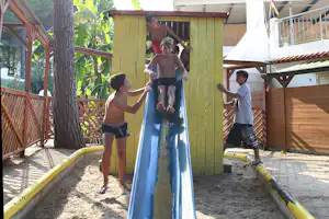 Camping Calabrisella - Sandkasten mit Rutsche und spielenden Kindern