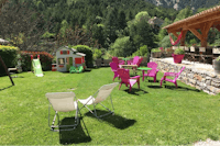 Camping Calme et Nature - WIese auf dem Campingplatz beim Imbiss mit Sitzgelegenheiten im Freien und Spielhütte für Kinder