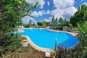 Camping Camp Redon - Pool im Freien mit Liegestühlen und Sonnenschirmen