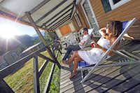 Campéole Le Courounba  -  Camper auf der Veranda vom Mobilheim auf dem Campingplatz mit Blick auf die Alpen