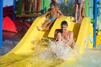 Camping Capalonga - planschende Kinder auf einer Rutsche im Schwimmbecken 