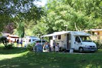 Camping-Caravaning Clair Matin -Wohnmobil mit davor sitzender Familie