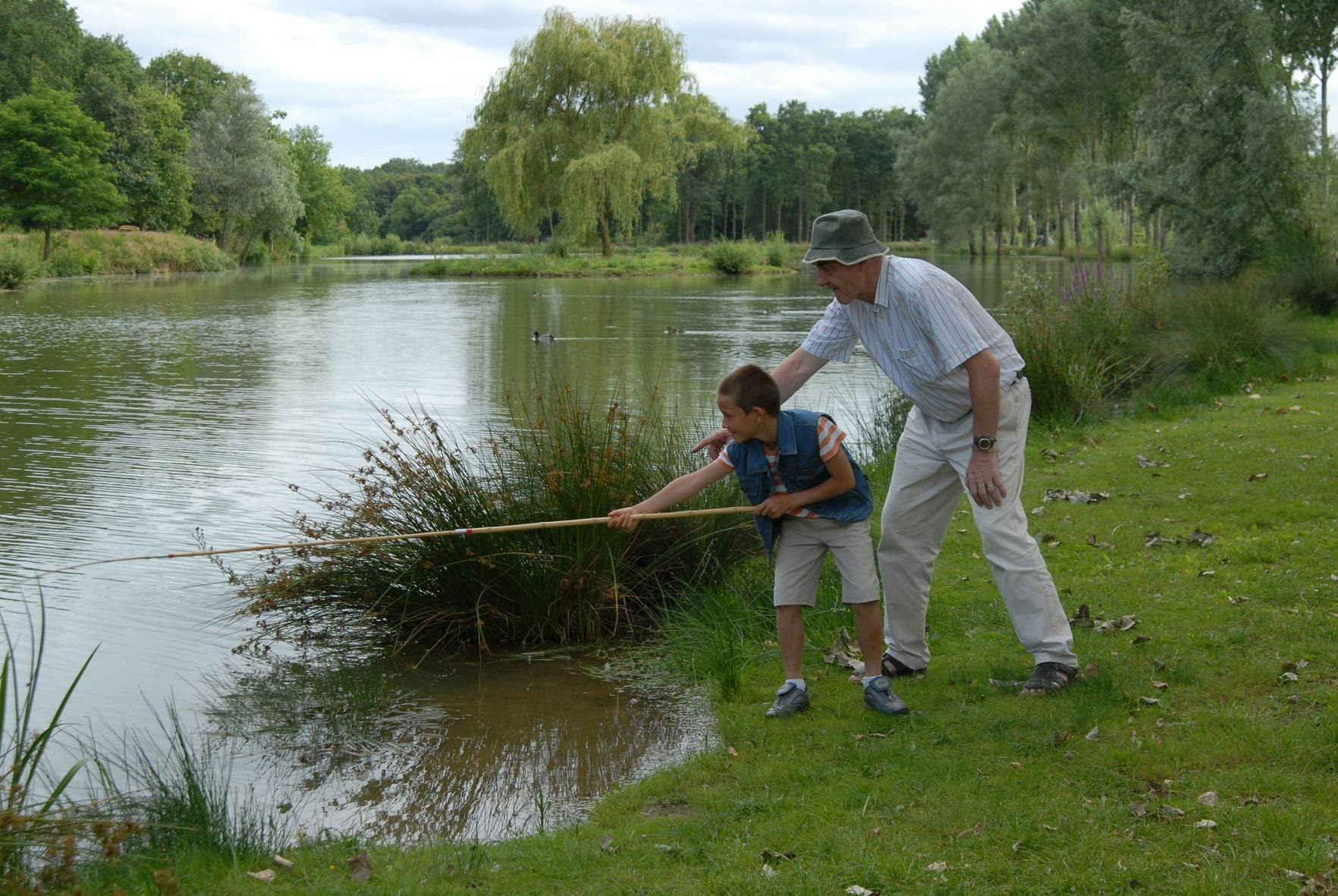 Siblu Camping Domaine de Dugny  Camping Caravaning Domaine de Dugny - Kind und Camper beim Angeln auf dem Campingplatz