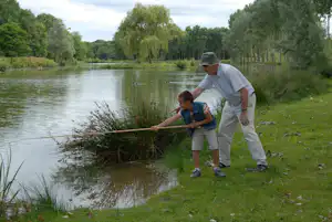 Siblu Camping Domaine de Dugny Camping Caravaning Domaine de Dugny - Kind und Camper beim Angeln auf dem Campingplatz