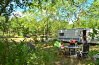 Camping Caravaning Domaine de la Bergerie - Wohnwagen mit Familie, die im Schatten der Bäume sitzt