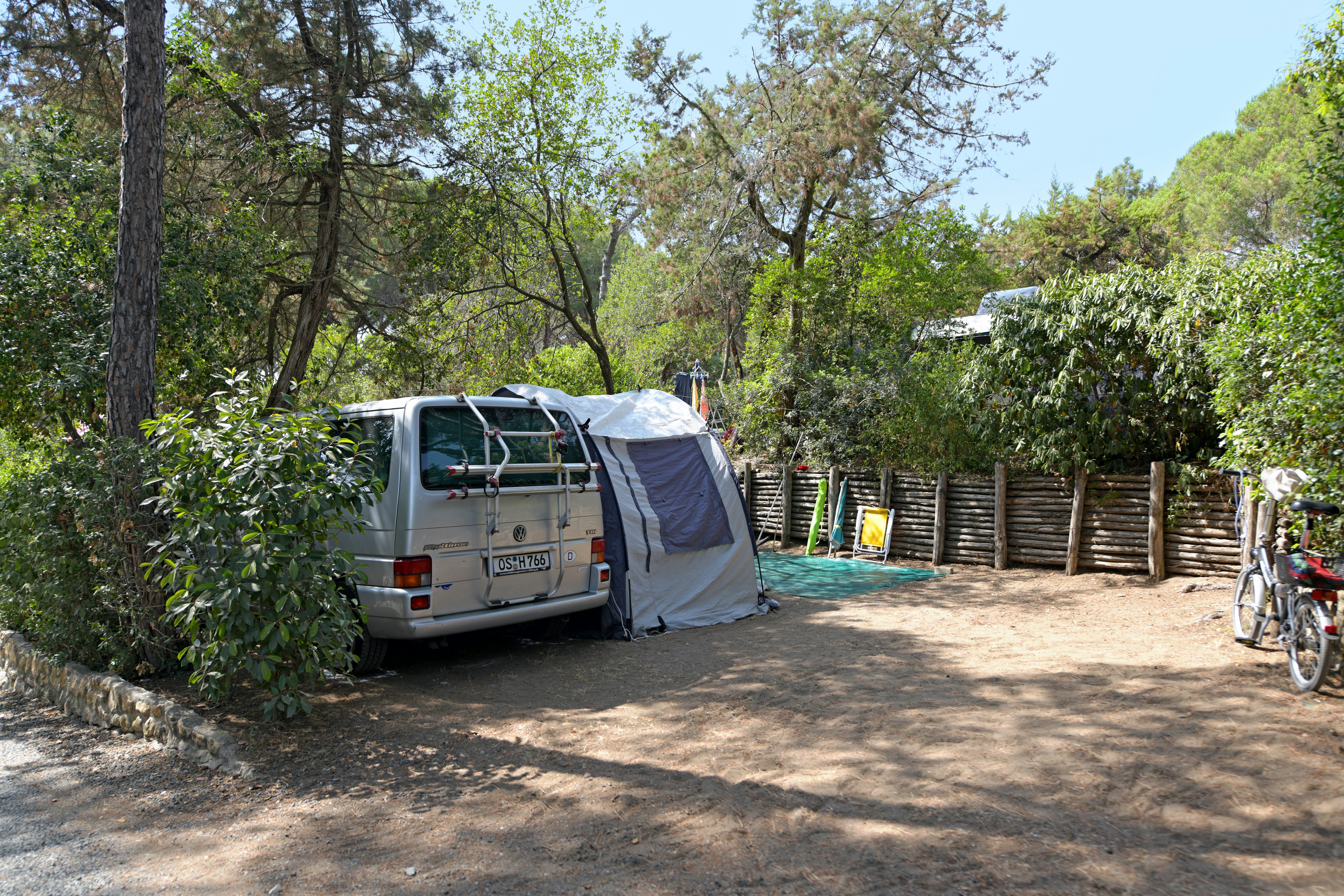 Camping Village Casa di Caccia - Standplatz teilweise im Halbschatten unter Bäumen