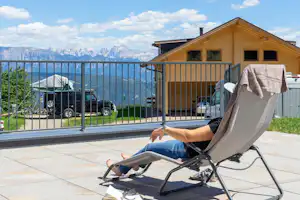 Camping Chalet Natur Idyll Salten - Camper im Liegestuhl mit Blick auf die Alpen