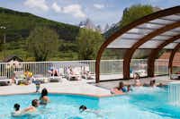Camping Champ la Chèvre - Pool vom Campingplatz mit Liegestühlen in der Sonne und Blick auf die Alpen