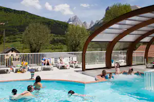 Camping Champ la Chèvre - Pool vom Campingplatz mit Liegestühlen in der Sonne und Blick auf die Alpen