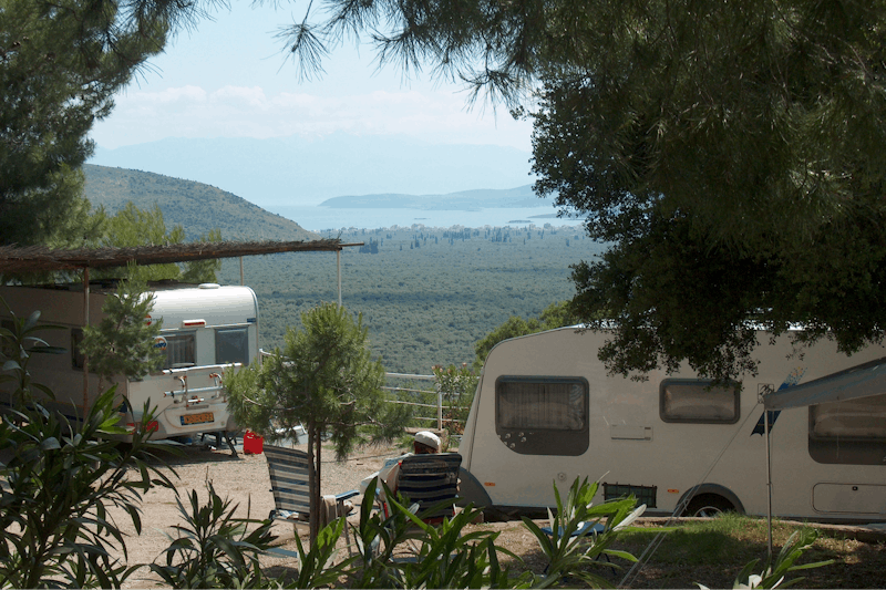 Camping Chrissa  -  Wohnwagen und Wohnmobile auf überdachten Stellplätzen vom Campingplatz  mit Meerblick