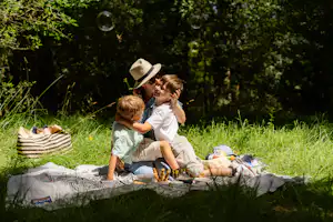 Camping Sunêlia Le Petit Bois - Mutter mit Kindern beim Picknicken auf einer Wiese