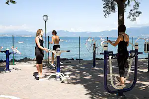 Camping Cisano - Trainingsgerät im Schatten der Baüme auf dem Campingplatz- mit Blick auf den See