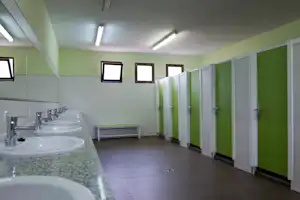 Camping Ciudad de Albarracin - Sanitärbereich vom Campingplatz mit Waschbecken, Spiegel und Kabinen