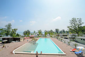 Camping Class - Blick vom Pool auf den Wohnwagen- und Zeltstellplatz und den See